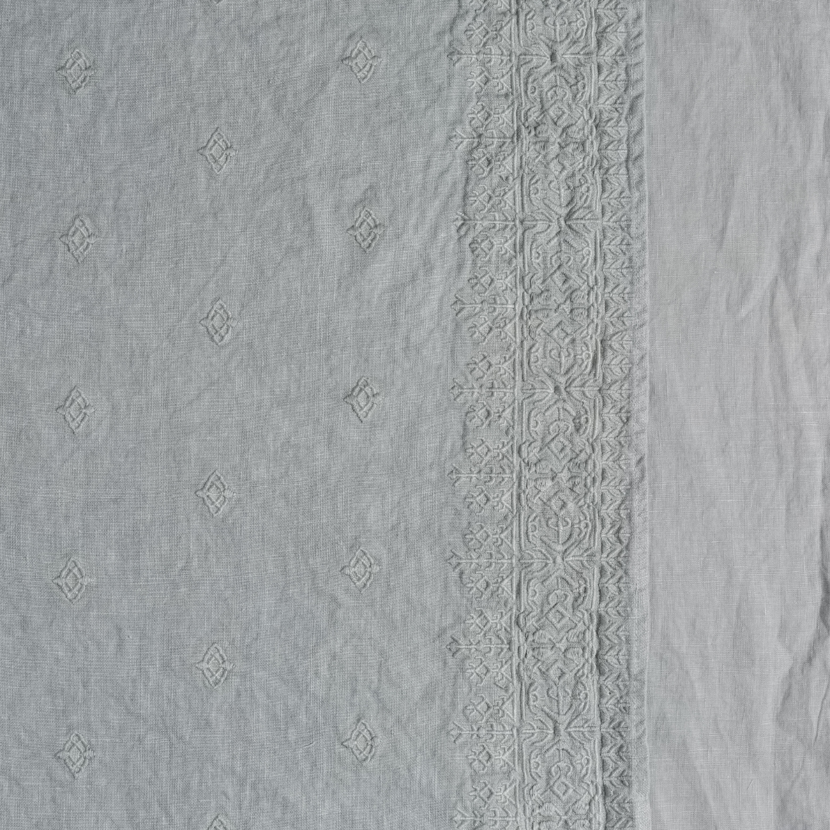 Ines Guest Towel | Mineral | A close up of embroidered midweight linen fabric in mineral, a soothing seafoam blue with subtle grey-green undertones.