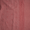 Ines Blanket | Poppy | A close up of embroidered midweight linen fabric in poppy, a warm coral pink.