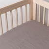 French Lavender | linen crib sheet shown on a mattress shot into the inside corner of the crib.