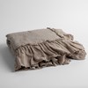 Linen Whisper Baby Blanket | Fog | a folded linen with linen whisper ruffled blanket folded and positioned to show the ruffle detail against a white background and slightly overhead.