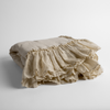Linen Whisper Baby Blanket | Parchment | a folded linen with linen whisper ruffled blanket folded and positioned to show the ruffle detail against a white background and slightly overhead.