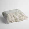 Linen Whisper Baby Blanket | Winter White | a folded linen with linen whisper ruffled blanket folded and positioned to show the ruffle detail against a white background and slightly overhead.