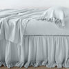 Linen Whisper Bed Skirt | Cloud | bed skirt layered with monochromatic linen sheeting - side view.