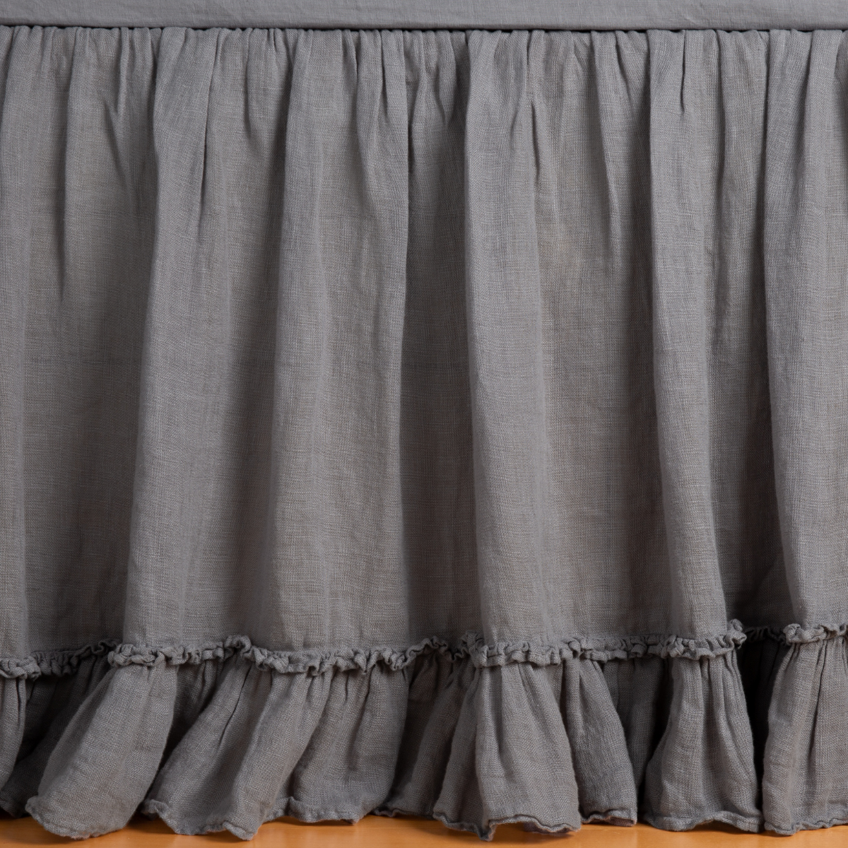 Linen Whisper Bed Skirt | French Lavender | bed skirt panel shown with a matching fitted sheet - the ruffle on the skirt gently fluttering against the floor.