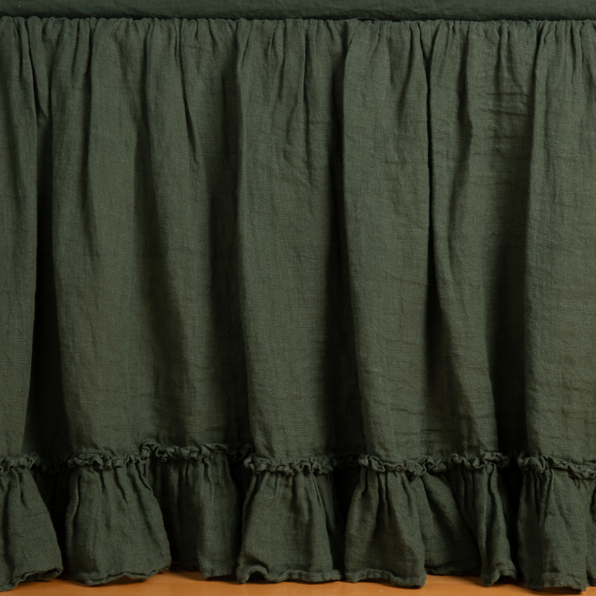 Linen Whisper Bed Skirt | Juniper | ruffled bed skirt panel shown with matching fitted sheet, the skirt gently skimming the floor.