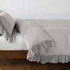 Linen Whisper Duvet Cover | Fog | duvet cover folded back over a white fitted sheet, shown with matching sham against a plain background - side view.