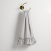 Linen Whisper Guest Towel | Cloud | guest towel draped through a decorative brass towel ring, against a white wall.
