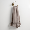 Linen Whisper Guest Towel | Fog | guest towel draped through a decorative brass towel ring, against a white wall.