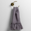 Linen Whisper Guest Towel | French Lavender | ruffled linen guest towel on a decorative towel ring against a white wall.