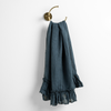 Linen Whisper Guest Towel | Midnight | guest towel draped through a decorative brass towel ring, against a white wall.