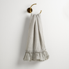 Linen Whisper Guest Towel | Mineral | guest towel draped through a decorative brass towel ring, against a white wall.