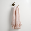 Linen Whisper Guest Towel | Pearl | guest towel draped through a decorative brass towel ring, against a white wall.