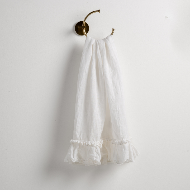 Linen Whisper Guest Towel | Winter White | guest towel draped through a decorative brass towel ring, against a white wall.