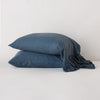 Linen Whisper Pillowcase (Single) | Midnight | Two sleeping pillows stacked at a slight angle against a plain background, showcasing ruffle trim detail - side view.
