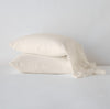 Linen Whisper Pillowcase (Single) | Parchment | Two sleeping pillows stacked at a slight angle against a plain background, showcasing ruffle trim detail - side view.