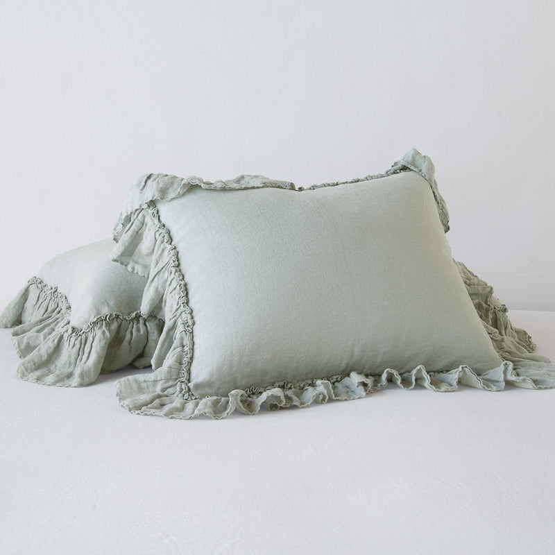 Linen Whisper Sham | Eucalyptus | standard sham leaning against a king sham laying flat, on a plain background.