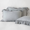 Linen Whisper Sham | Mineral | two shams leaning upright and one laying flat at an angle in the foreground, against a blank background.