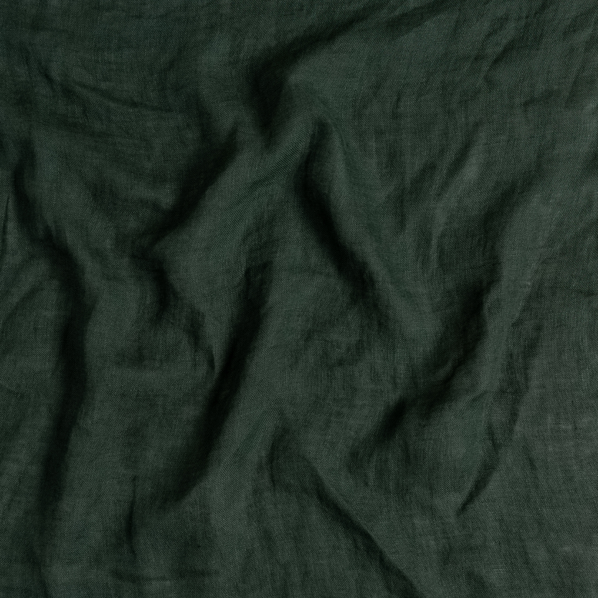 Linen Whisper Bed Skirt | Juniper | A close up of linen whisper fabric in Juniper, a deep green tone.