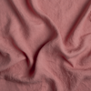 Linen Bed Skirt | Poppy | A close up of linen fabric in poppy, a warm coral pink.