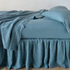 Linen Twin Bed Skirt | Cenote | bed skirt with matching rumpled sheets and sleeping pillows - side view.