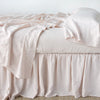 Linen Bed Skirt | Pearl | bed skirt with matching rumpled sheets and sleeping pillows - side view.