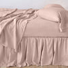 Linen Twin Bed Skirt | Rouge | bed skirt with matching rumpled sheets and sleeping pillows - side view.