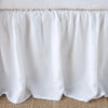 Close-up of linen bed skirt in white, featuring its softly gathered design.