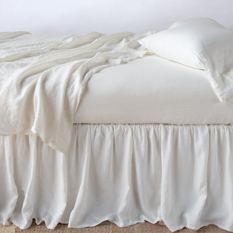Linen Bed Skirt | Winter White | bed skirt with matching rumpled sheets and sleeping pillows - side view.