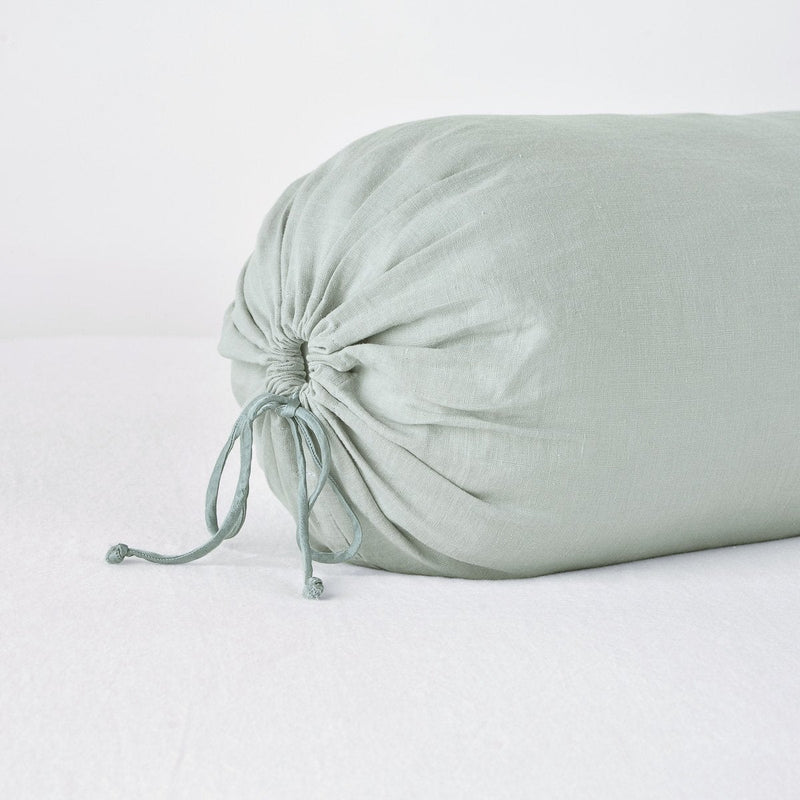 Linen Throw Pillow | Eucalyptus | Close-up bolster end detail, angled view to show gathered closure and satin ties.