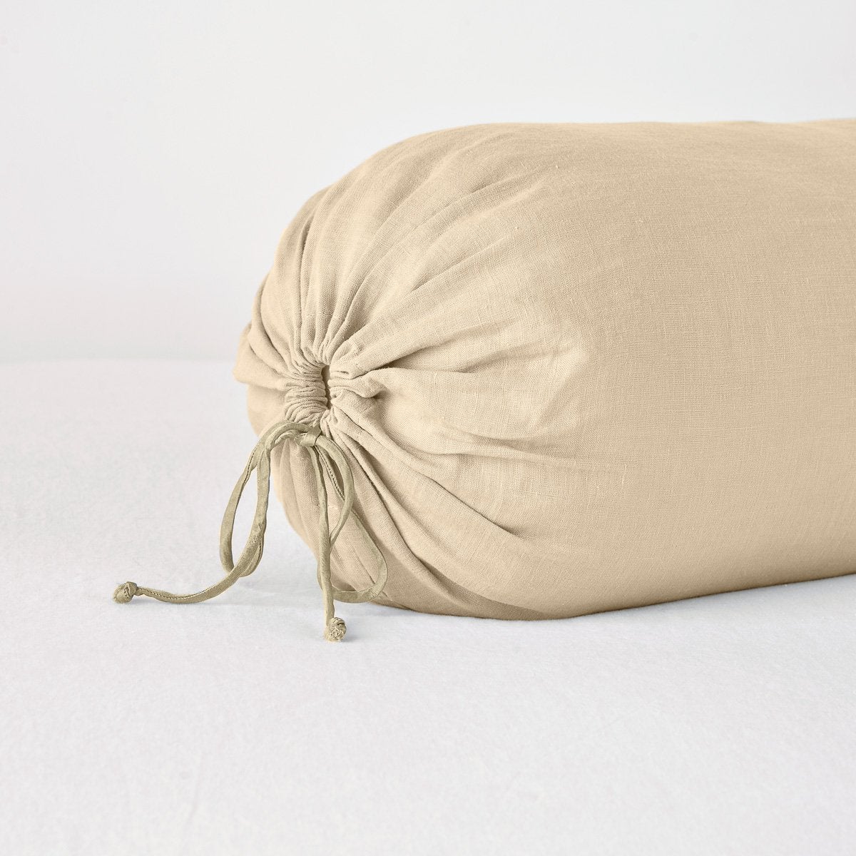 Linen Throw Pillow | Honeycomb | Close-up bolster end detail, angled view to show gathered closure and satin ties.
