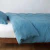 Linen Duvet Cover | Cenote | duvet cover neatly folded back over white linen sheeting - side view.