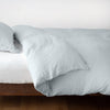 Linen Twin Duvet Cover | Linen duvet cover in cloud, neatly folded back over linen sheeting -side view.