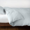 Cloud | Linen duvet cover in cloud, neatly folded back over linen sheeting -side view.