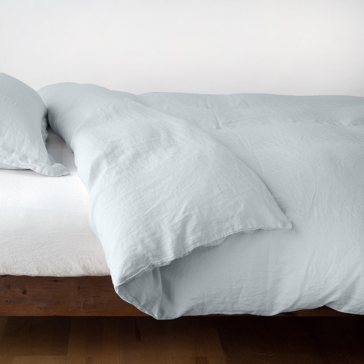 Cloud | Linen duvet cover in cloud, neatly folded back over linen sheeting -side view.