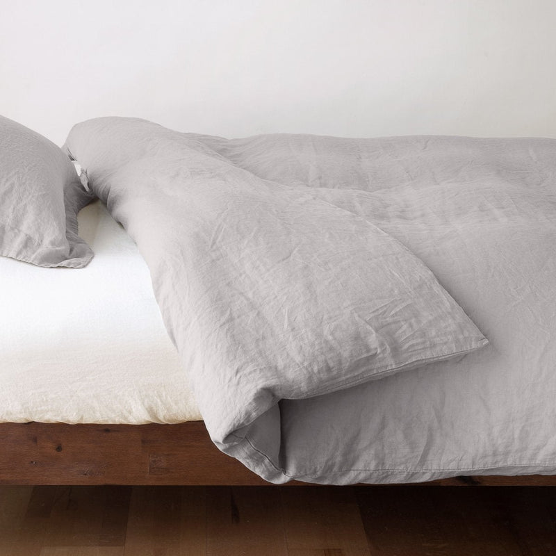 Linen Twin Duvet Cover | Fog | duvet cover neatly folded back over white linen sheeting - side view.