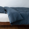 Linen Duvet Cover | Midnight | duvet cover neatly folded back over white linen sheeting - side view.