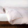 Linen Twin Duvet Cover | Pearl | duvet cover neatly folded back over white linen sheeting - side view.