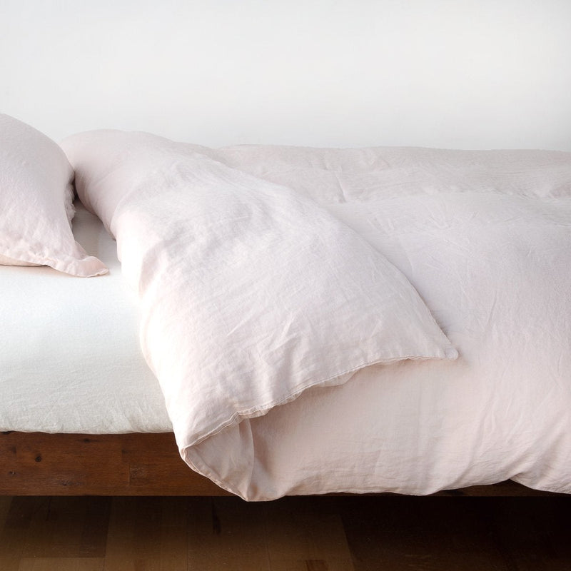 Linen Twin Duvet Cover | Pearl | duvet cover neatly folded back over white linen sheeting - side view.