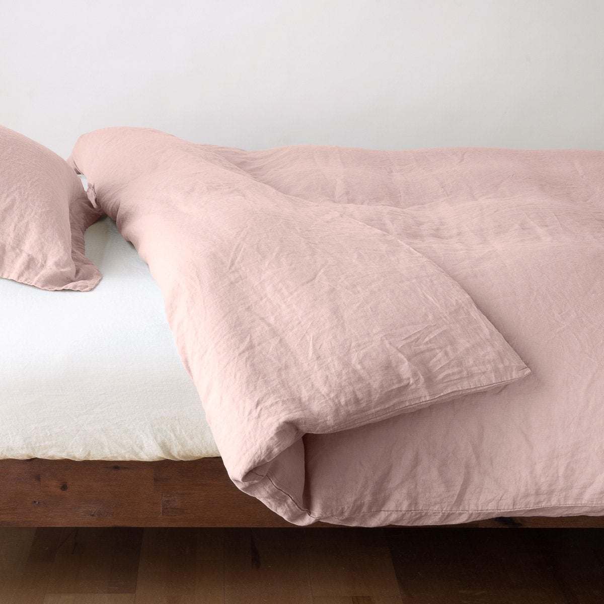 Linen Duvet Cover | Rouge | duvet cover neatly folded back over white linen sheeting - side view.