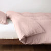 Linen Twin Duvet Cover | Rouge | duvet cover neatly folded back over white linen sheeting - side view.