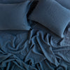 Linen Fitted Sheet | Midnight | fitted sheet with matching rumpled flat sheet and sleeping pillows - overhead view.