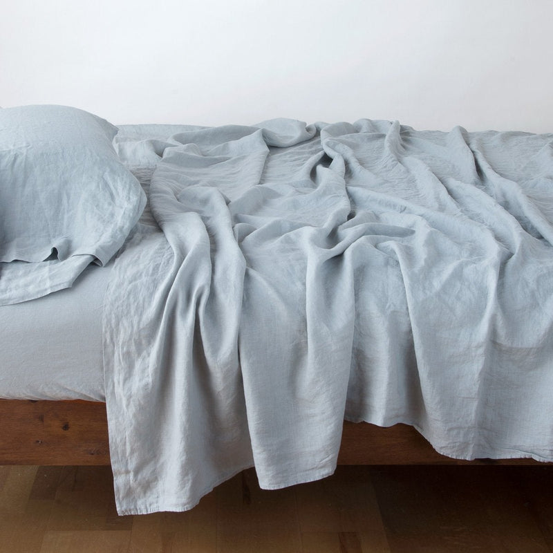Linen Fitted Sheet | Mineral | fitted sheet with matching rumpled flat sheet and sleeping pillow - side view.
