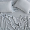 Linen Fitted Sheet | Mineral | fitted sheet with matching rumpled flat sheet and sleeping pillows - overhead view.