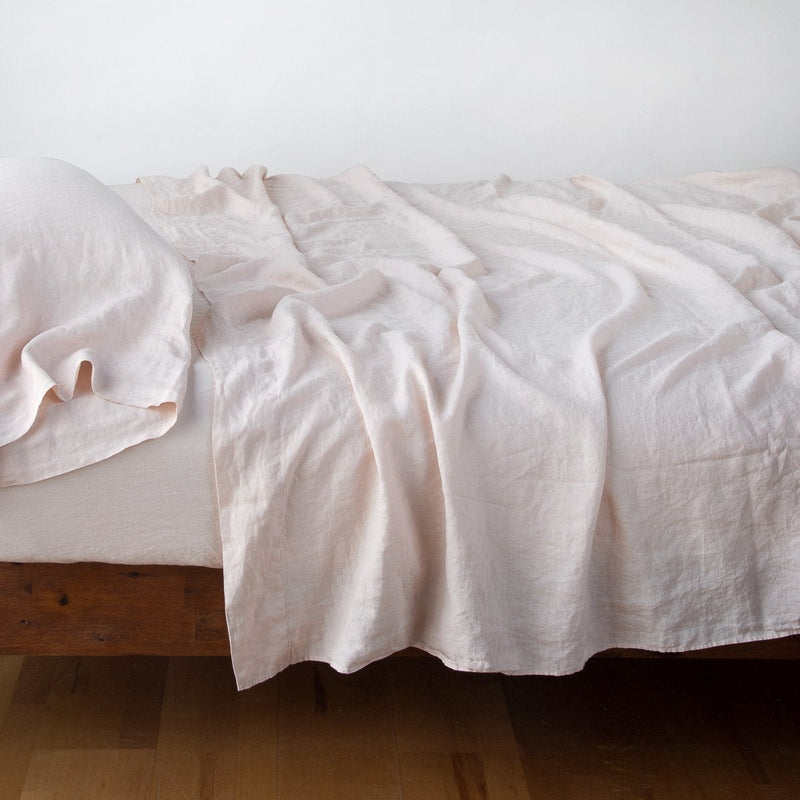 Linen Fitted Sheet | Pearl | fitted sheet with matching rumpled flat sheet and sleeping pillow - side view.