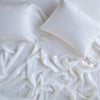 Linen Fitted Sheet | White | fitted sheet with matching rumpled flat sheet and sleeping pillows - overhead view.