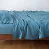Linen Twin Flat Sheet | Cenote | Rumpled linen sheeting with matching sleeping pillow - side view.