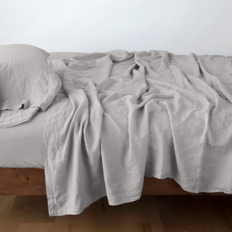 Linen Twin Flat Sheet | Fog | Rumpled linen sheeting with matching sleeping pillow - side view.