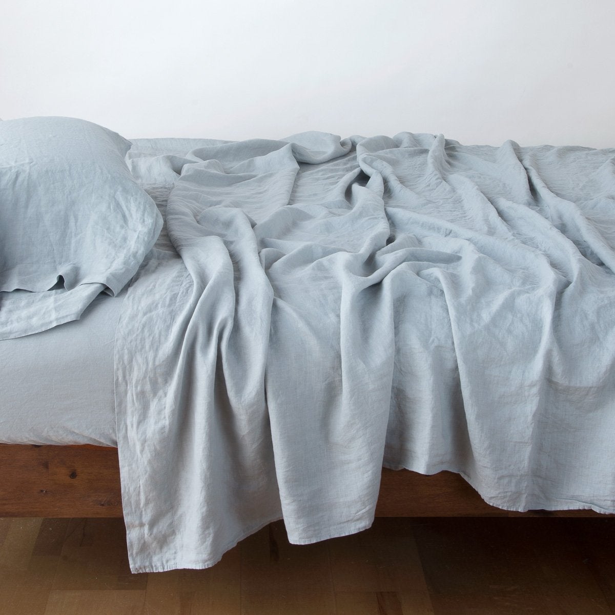 Linen Twin Flat Sheet | Mineral | Rumpled linen sheeting with matching sleeping pillow - side view.