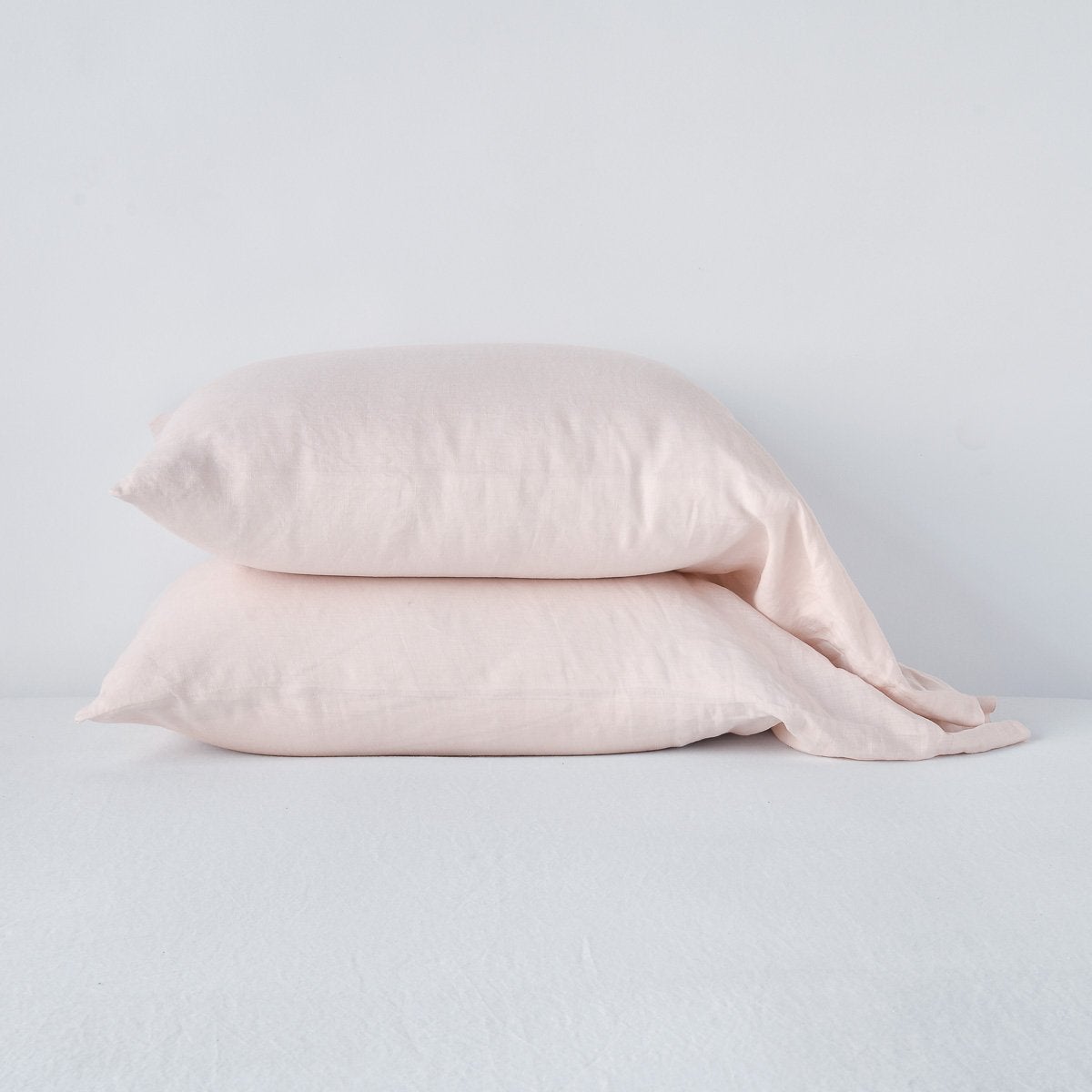 Linen Standard Pillowcase (Single) | Pearl | Two sleeping pillows neatly stacked against a white background - side view.