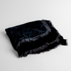 Loulah Baby Blanket | Midnight | an overhead shot of a folded silk velvet baby blanket with a raw-edged eyelash ruffle detail.